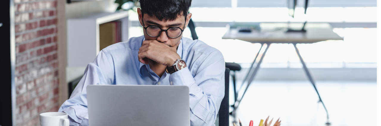 man in workplace setting looking at computer