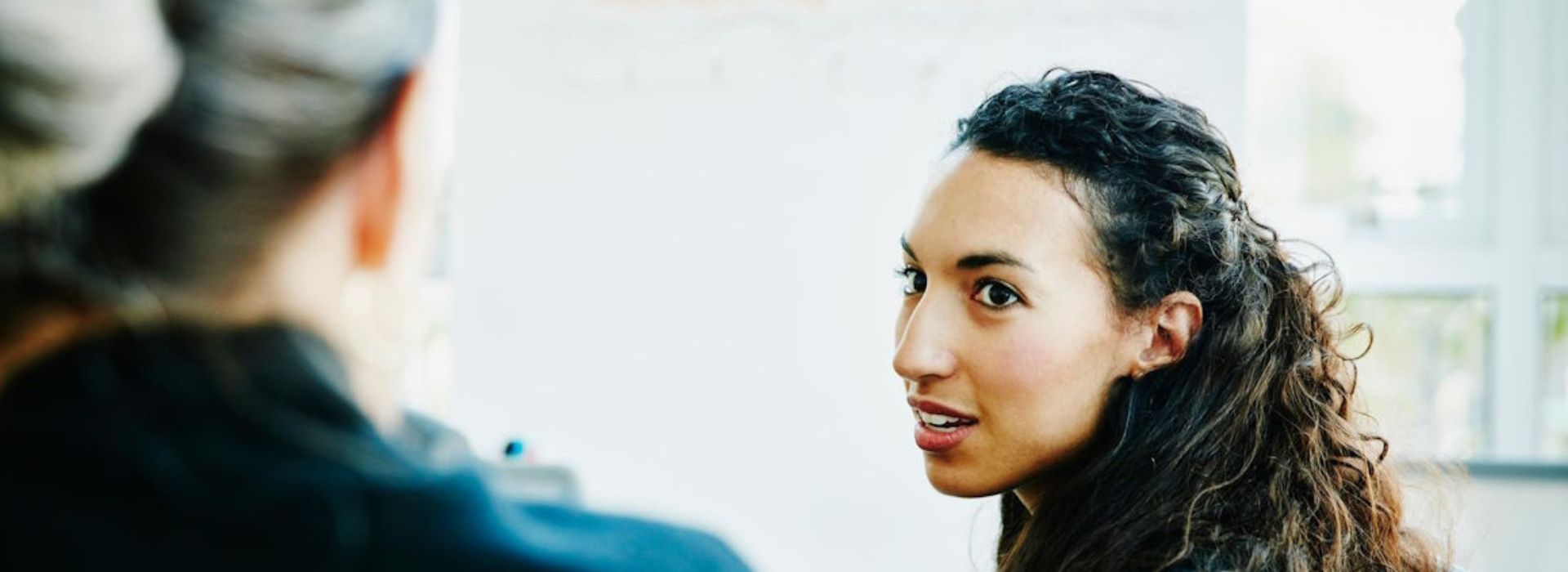 donna che si gira per parlare con un'altra persona che è di spalle