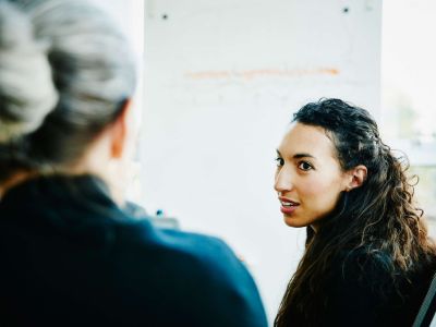 donna che si gira per parlare con un'altra persona che è di spalle