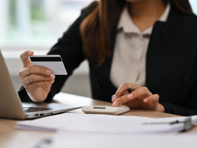 woman calculating while looking at bank card