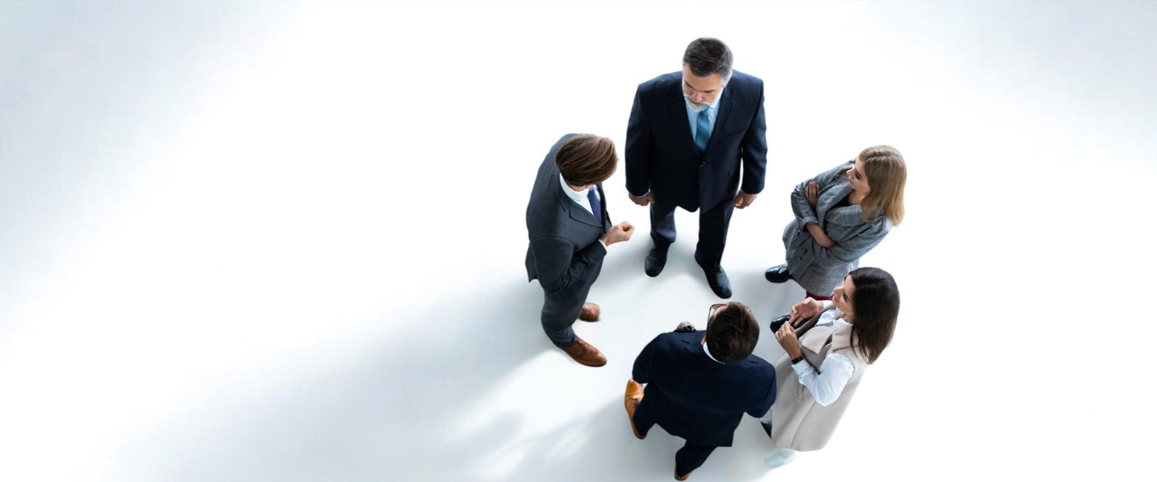 Directly above view of business colleagues in formalwear standing in lobby of company