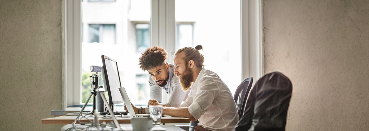 2 co-workers looking intently at computer