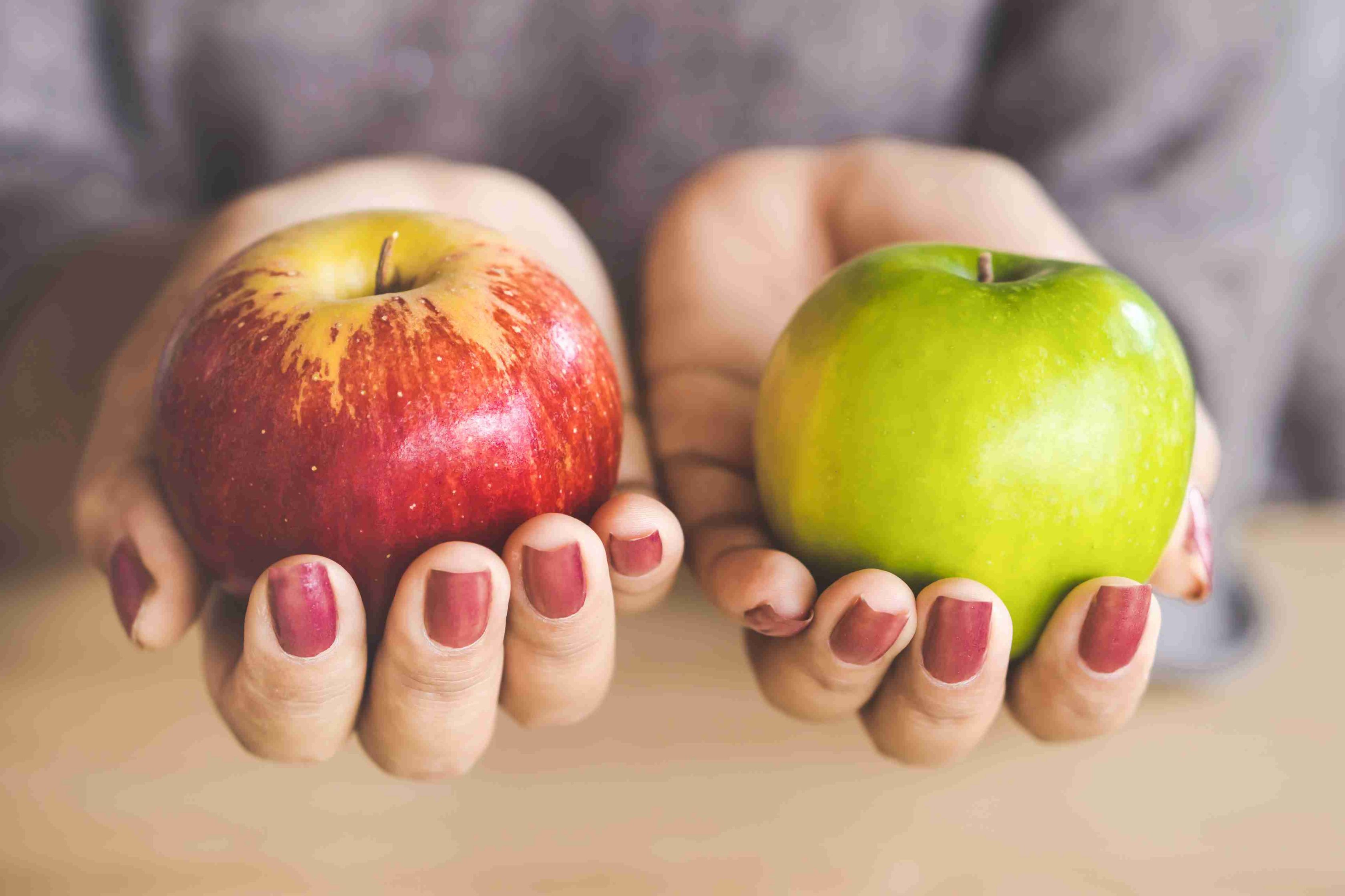 two hands holding two apples 