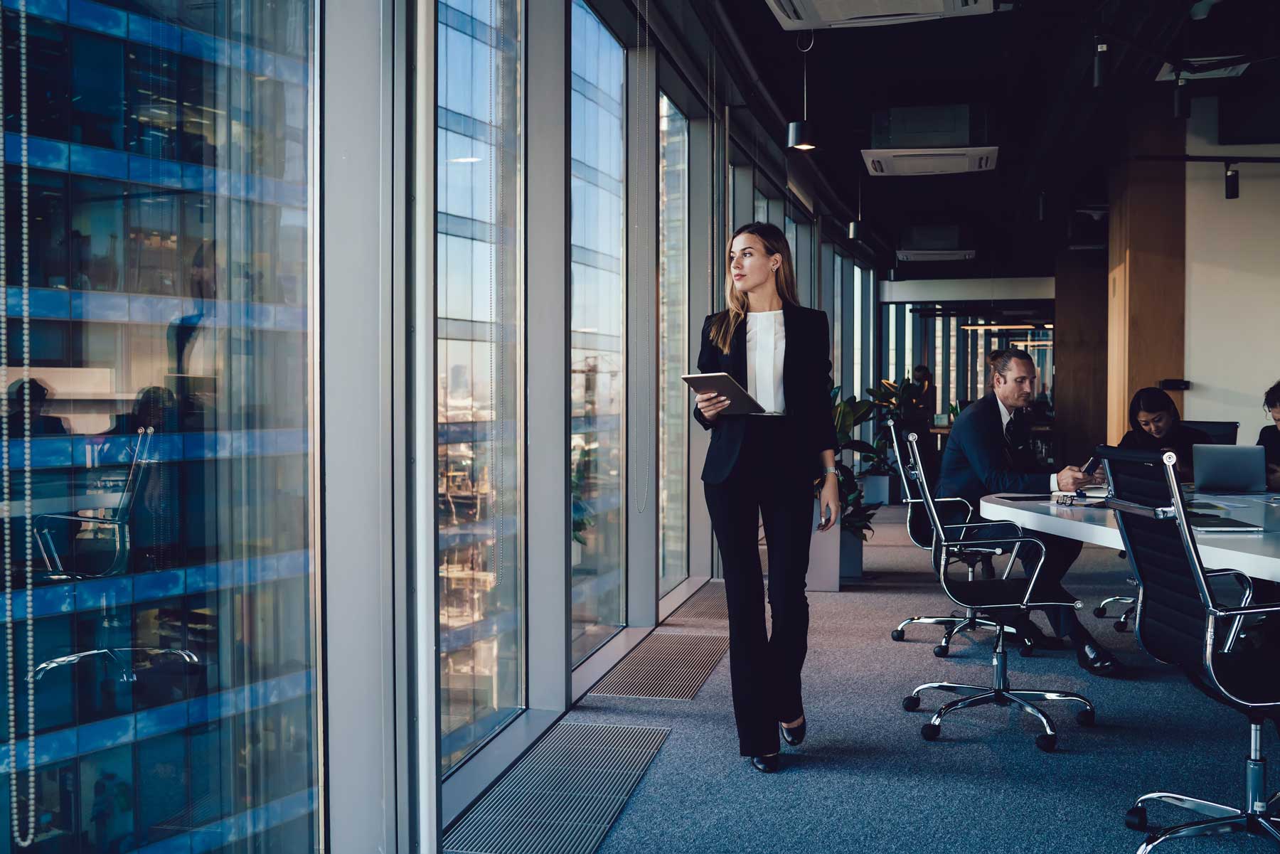 A woman walking and looking out the window