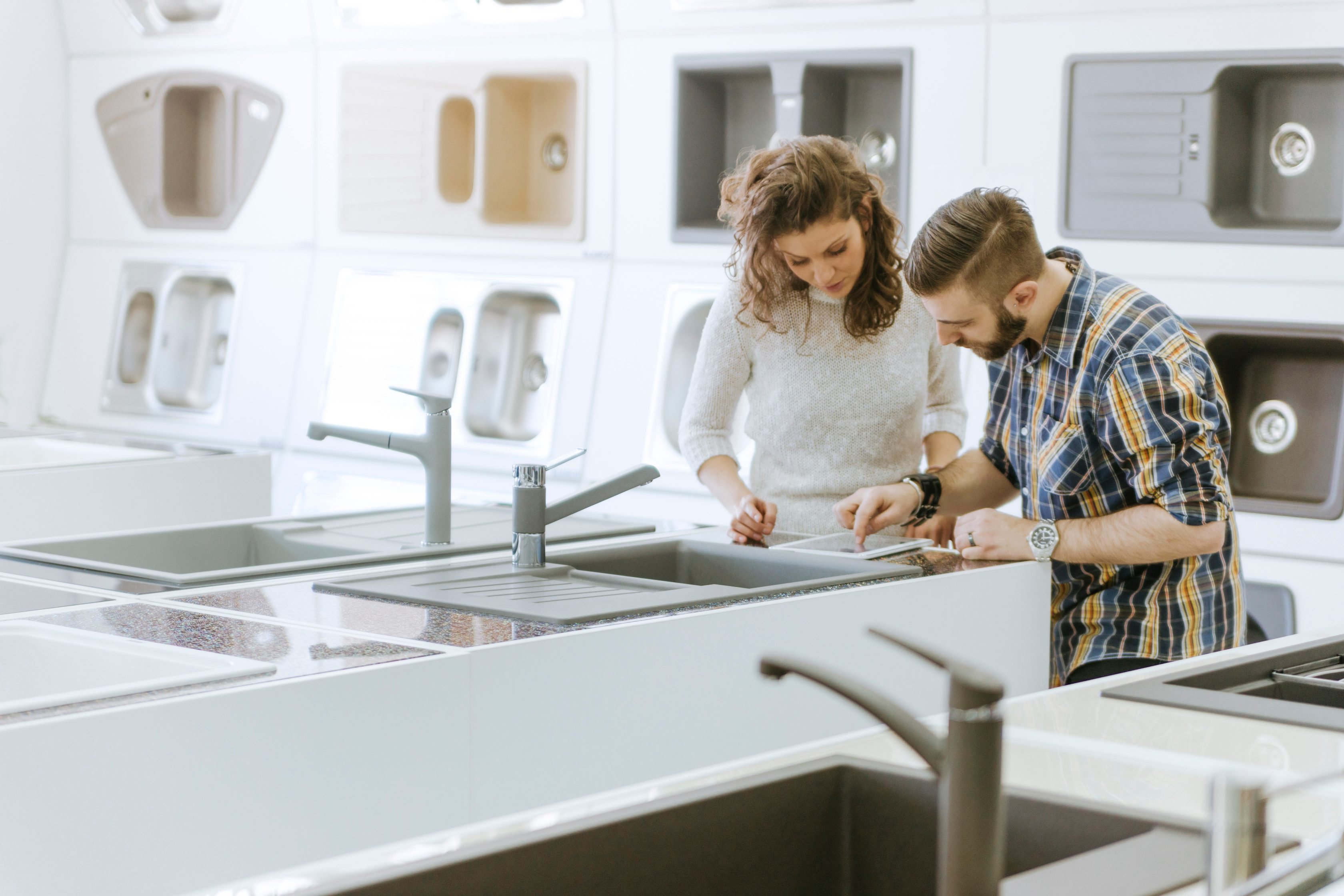 man and woman looking tablet in kitchen