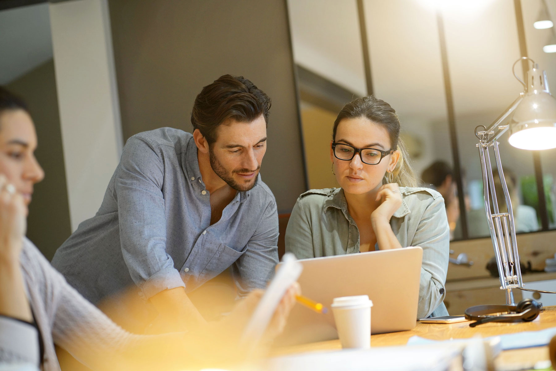 male and female worker intensely looking at laptop together