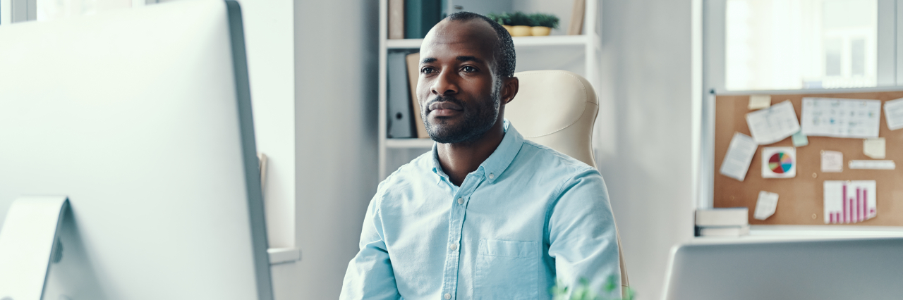man in workplace looking at computer