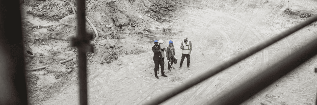 four workers standing on construction site and talking