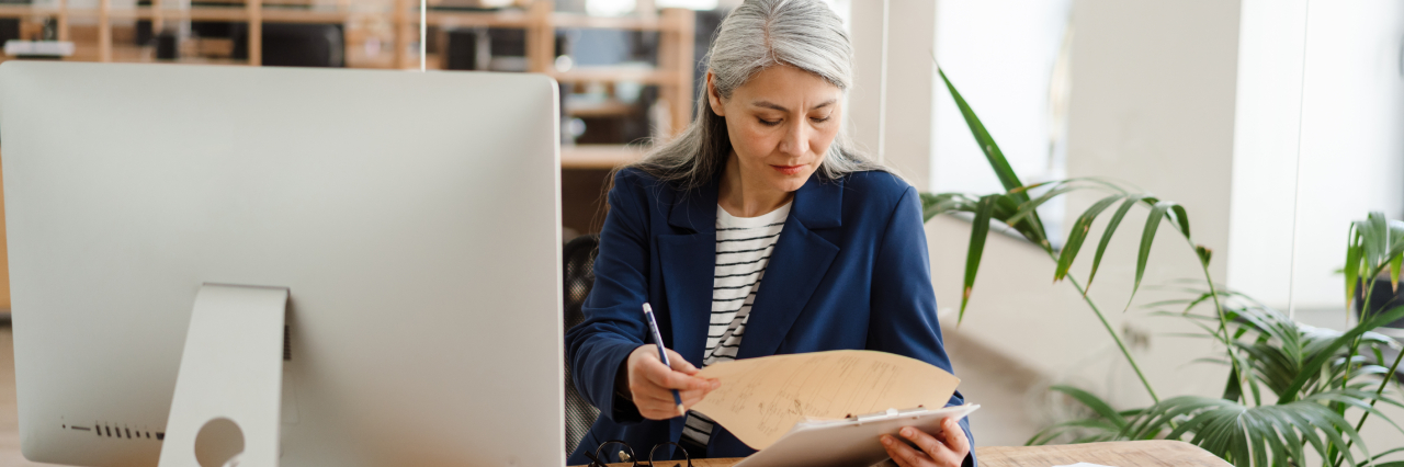 woman sitting down and writing with a pen