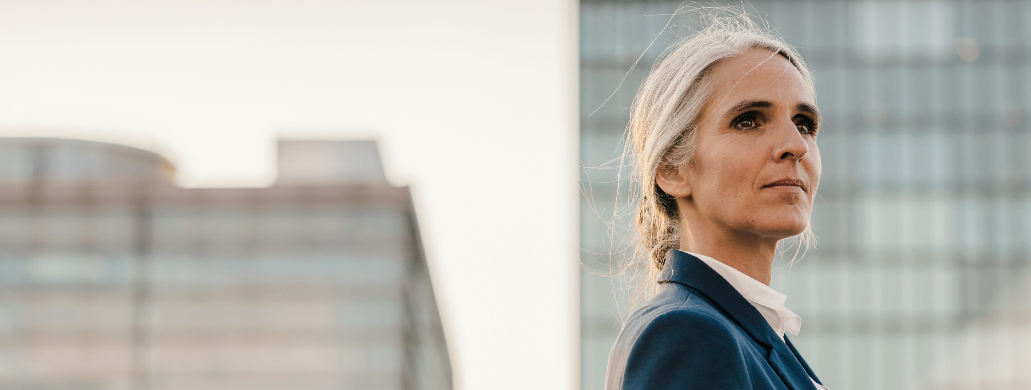 woman standing on balcony, looking out at city