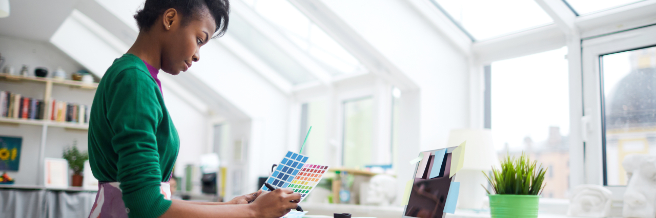 woman looking downward at paint colors