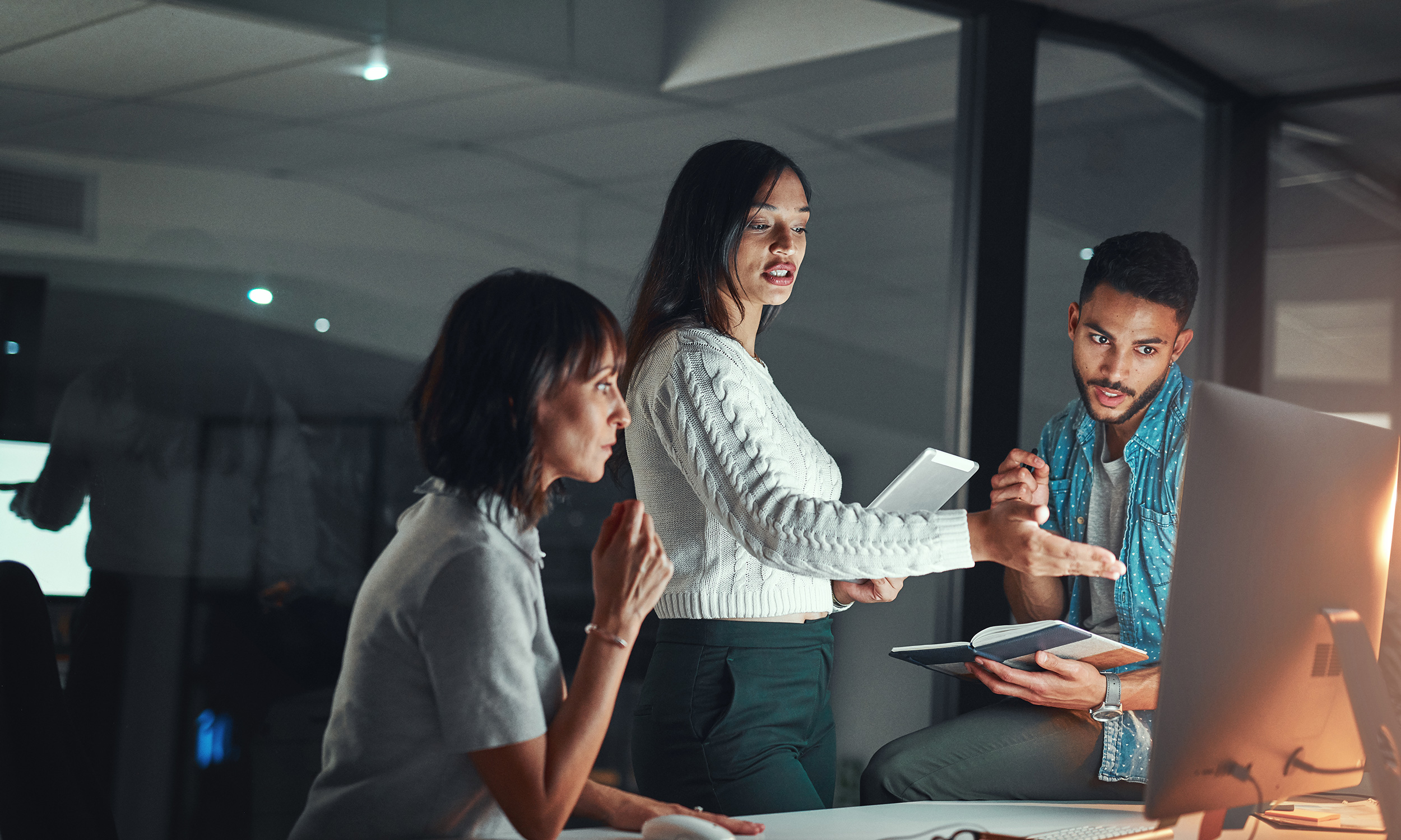 three co-workers looking at computer screen