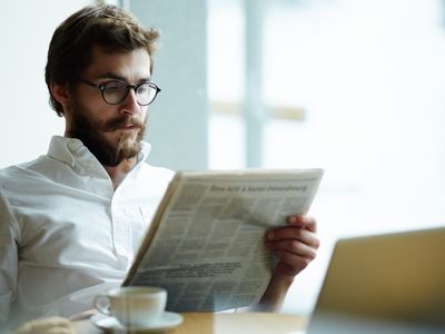 Un directeur lisant un journal financier.