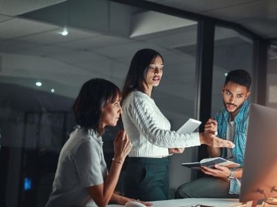 Trois collègues échangent dans une salle de réunion