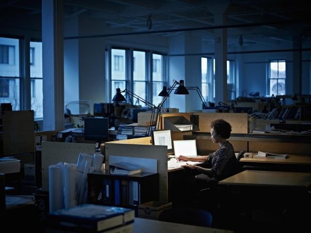 Un'impiegata lavora alla propria scrivania in un ufficio