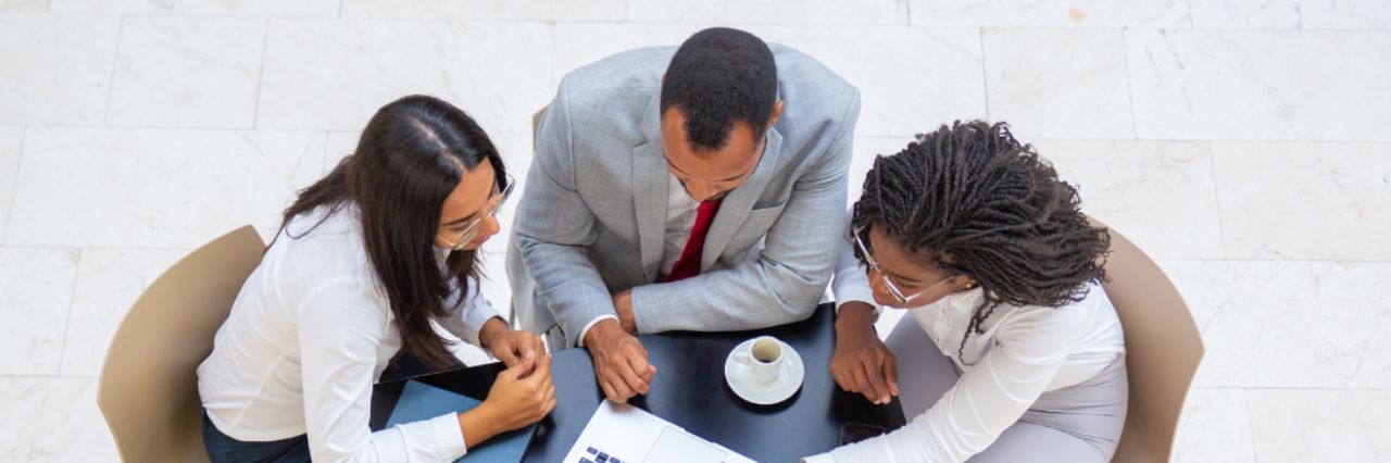 Team discute su progetto durante pausa caffè