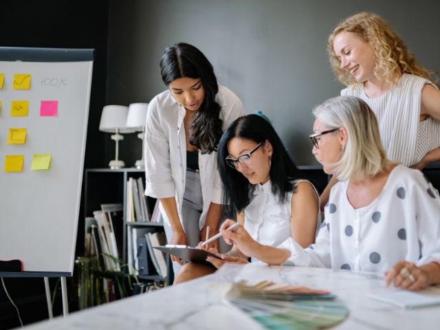 tre donne lavorano insieme in sala riunione