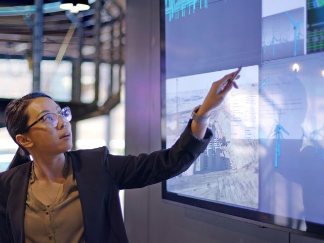 Giovane relatrice che presenta dati su energie rinnovabili e produzione energetica tradizionale