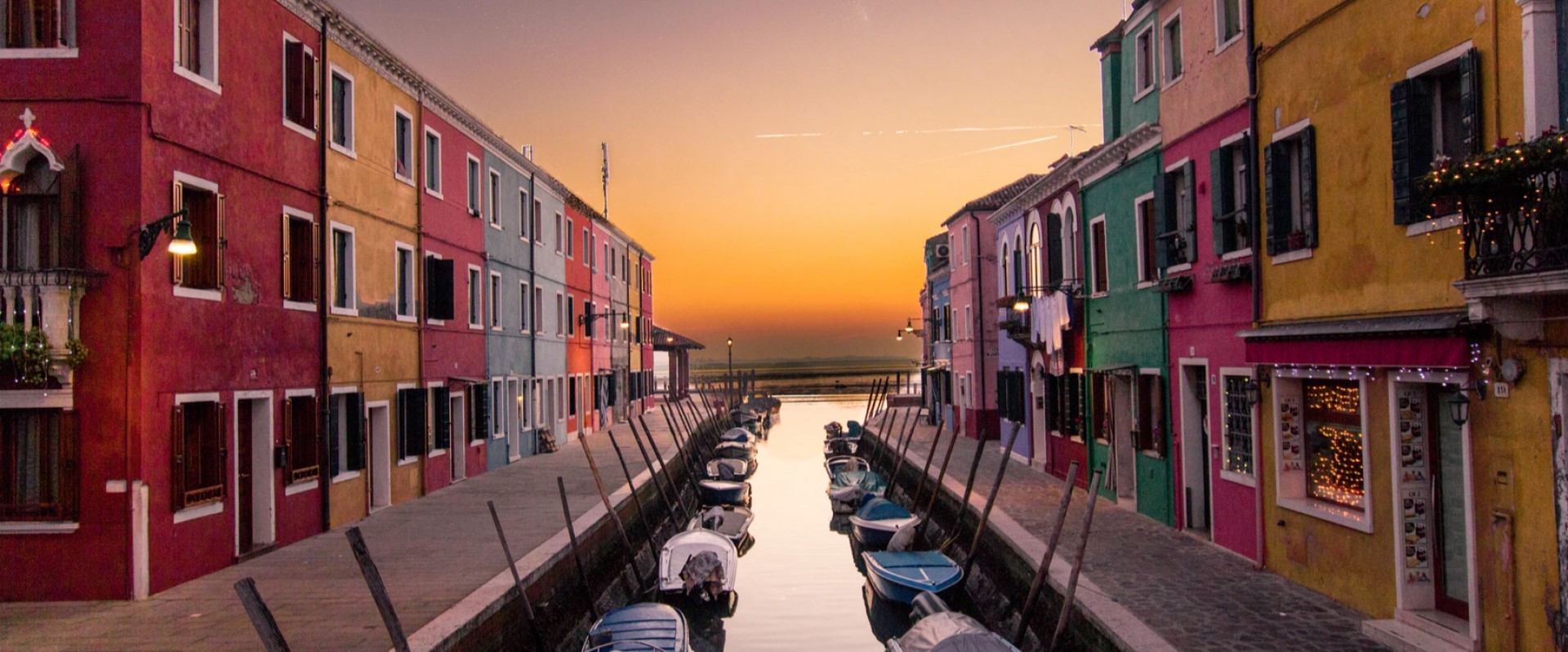 Canale con piccole imbarcazioni ormeggiate e costeggiato da edifici colorati