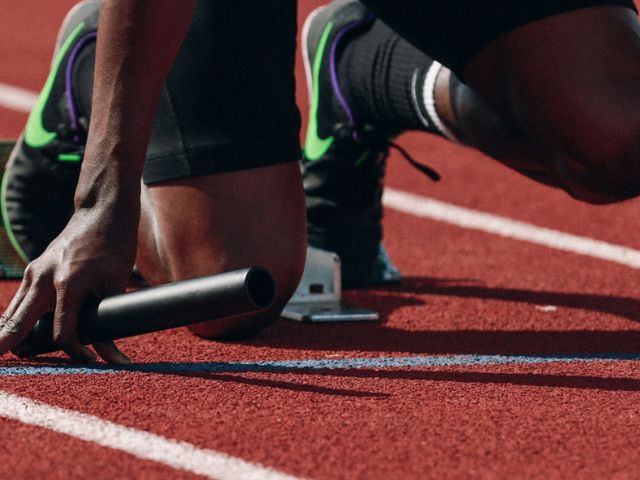 Atleta di una staffetta su un campo di atletica