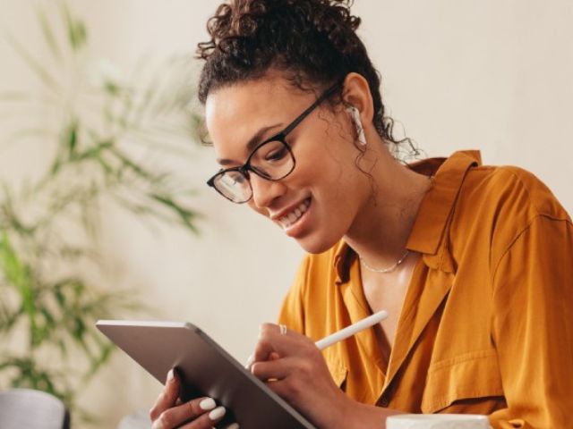 Un'imprenditrice lavora usando il tablet e una penna elettronica