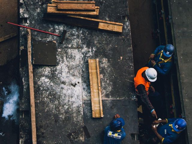 Vista dall'alto di quattro operai che lavorano in un quartiere