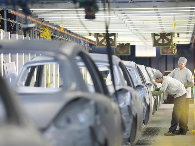 Due operai lavorano in un'industria di produzione automobilistica