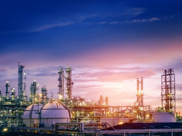 Vista di un'industria petrolchimica al tramonto