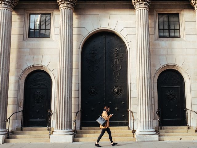 Una donna cammina davanti alla Banca d'Inghilterra