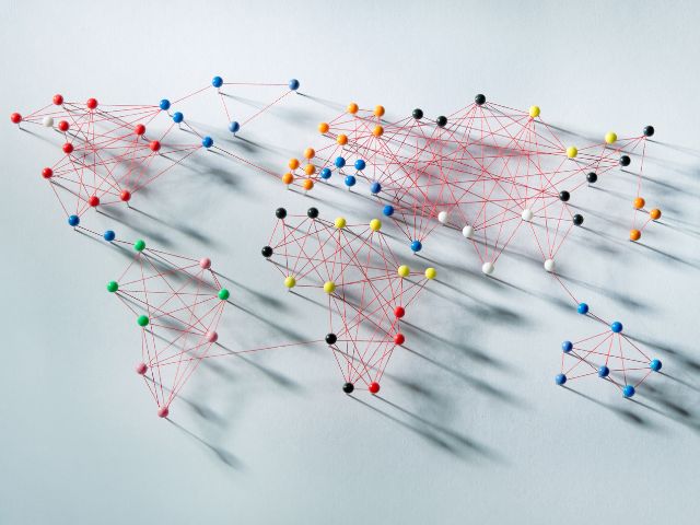 Planisfero ricreato con puntine colorati e fili tesi rossi