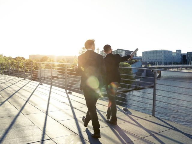 Due imprenditori camminano su un ponte nel distretto finanziario della città
