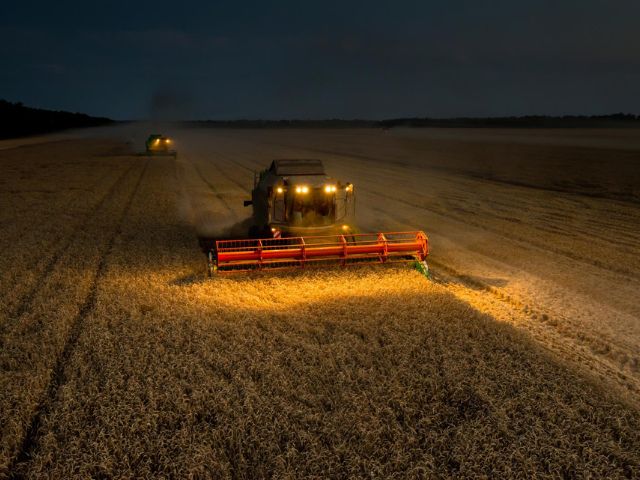 Due trattori arano un campo di notte