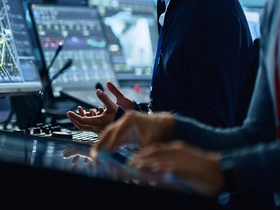 Due ingegneri lavorano in un centro di controllo con molti schermi