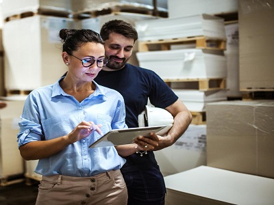 Una manager e un capo magazziniere consultato l'inventario usando un tablet