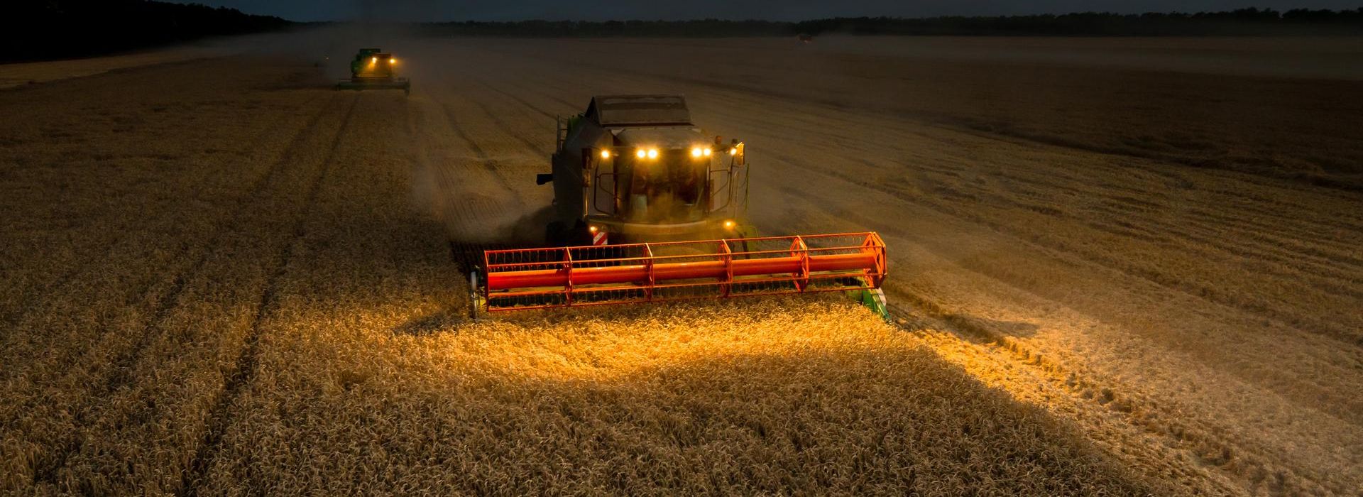Trattori che lavorano un campo di notte