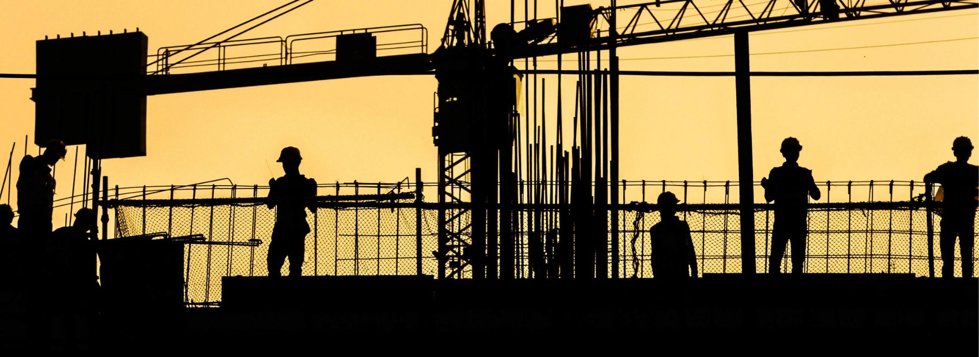 Operai al lavoro in un cantiere, in penombra