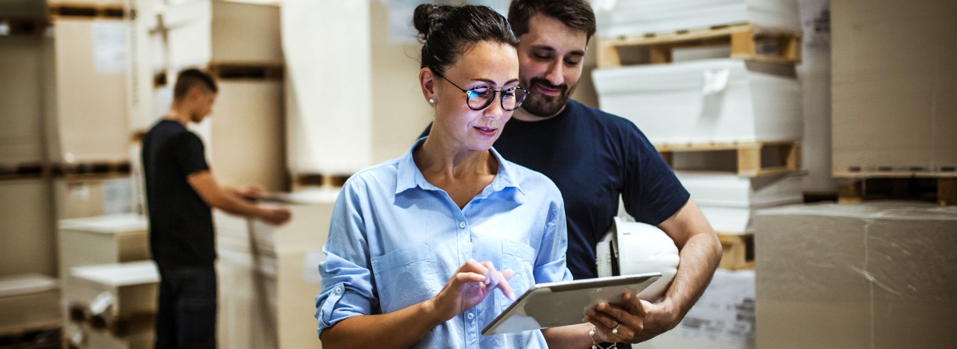 Una manager controlla dei dati sul tablet, commentandoli con un collega