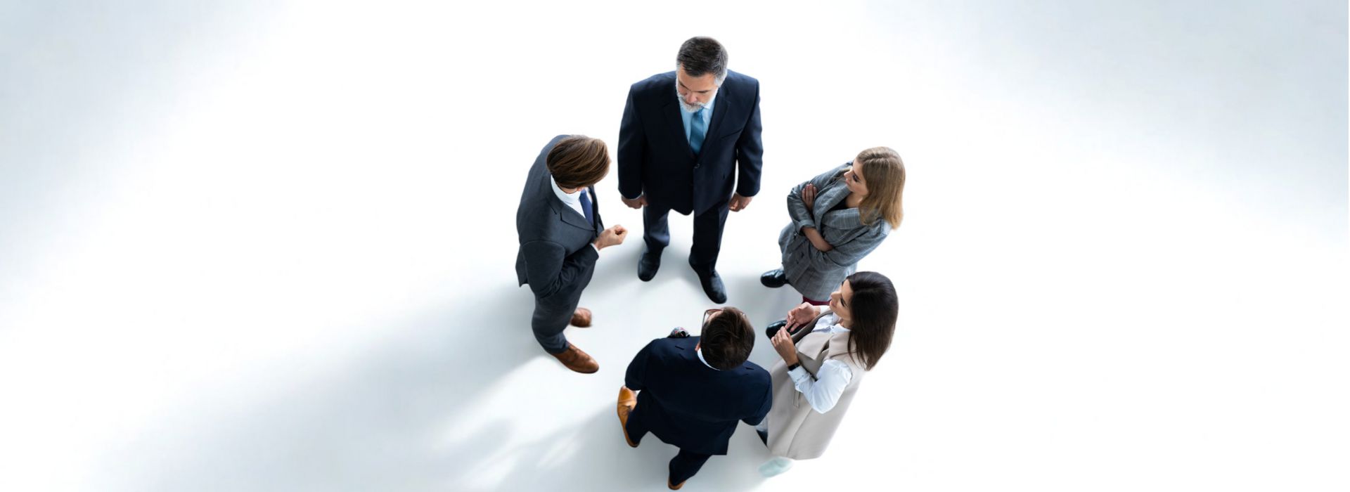 Vista-superior-de-cinco-empresarios-numa-reuniao-de-negocios-e-trabalho-em-equipa