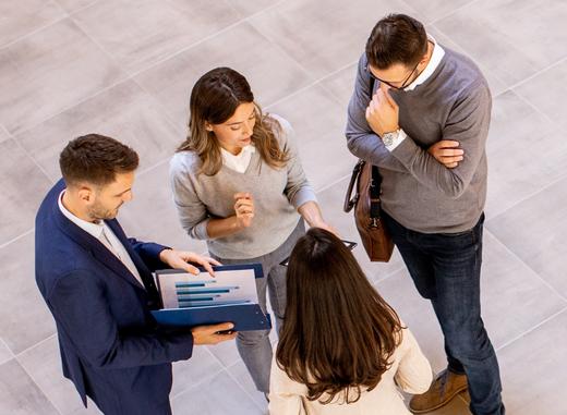 Four business people analyzing graphics and having a meeting