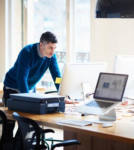 mann in einem büro vor seinem bildschirm am computer
