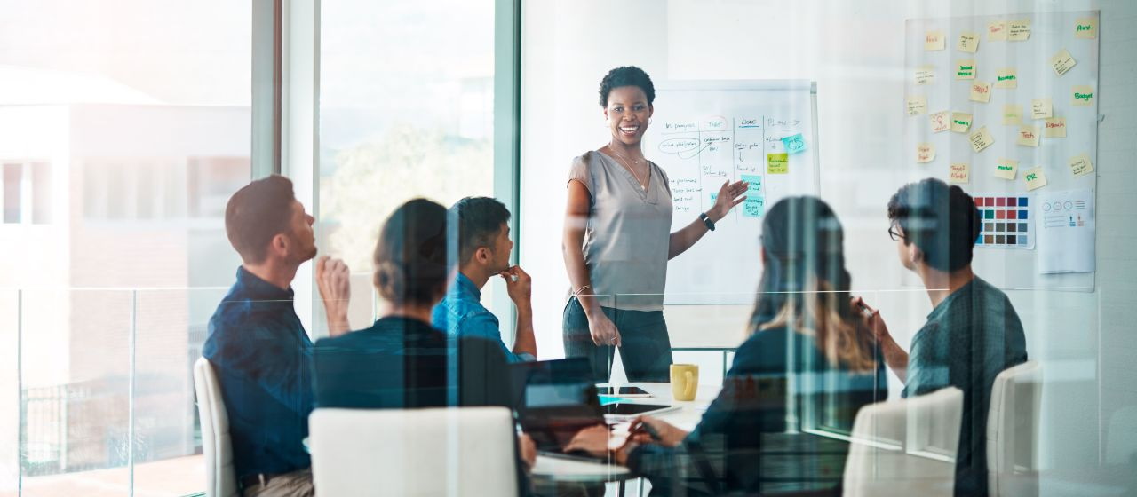 Six personnes discutent autour d'une table lors d'un meeting