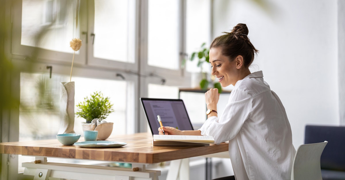 Une femme est assise à un bureau devant un ordinateur portable