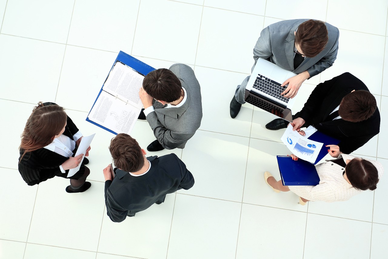 Six personnes discutent en entreprise