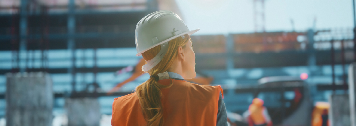 Une femme avec un casque de chantier et un chasuble orange