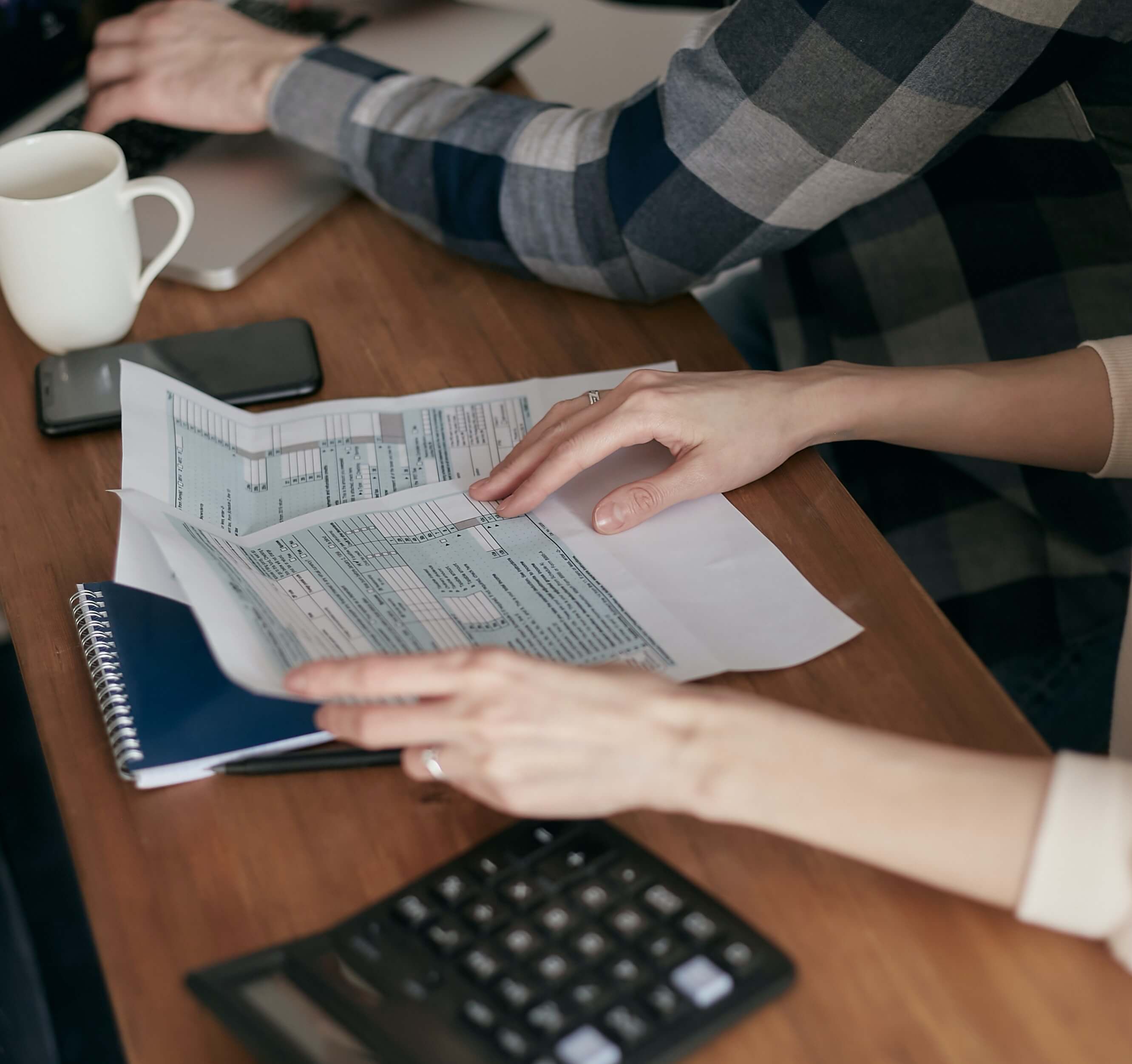 factures et calculatrice sur une table de réunion